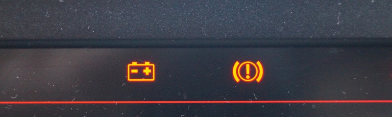 Car battery and warning light on dashboard
