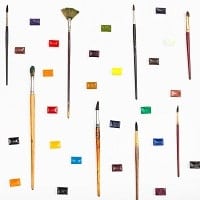 many paint brushes and watercolors arranged