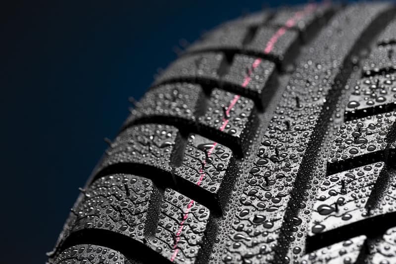 Car tire on black with rain